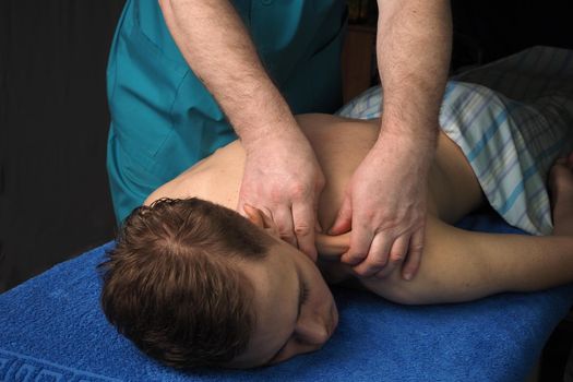 The back massage is manual. The specialist massages the back of the patient lying on the massage couch. High quality photo