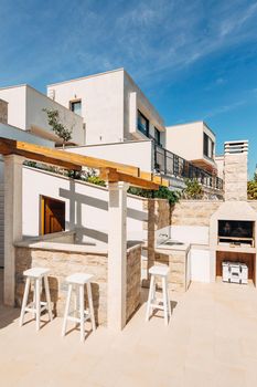 Grill area in the villa by the sea. A large courtyard with a stone grill and an open white stone kitchen. High quality photo