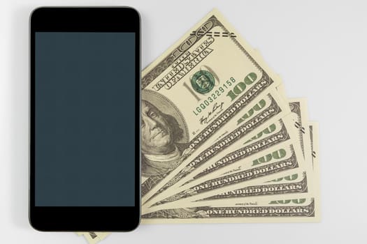 Close up Smartphone on US banknotes of one hundred dollars