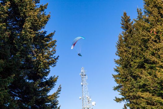 sports paragliding on a parachute over the countryside.