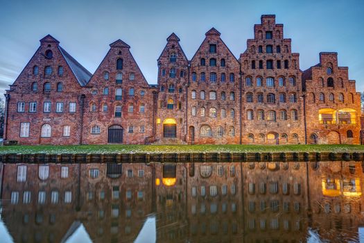 The old Salzspeicher reflecting in the Trave river at dawn, seen in Luebeck, Germany