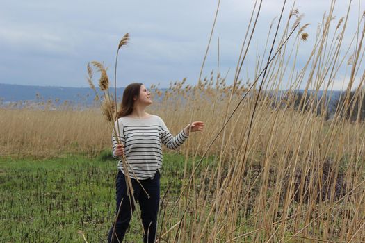 Portrait of a girl of European appearance in nature in a field against the background of high wheat. High quality photo