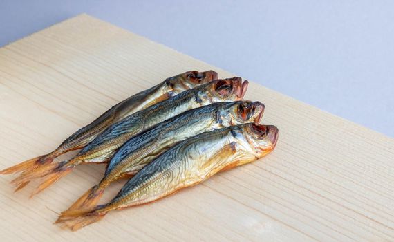 Horse mackerel fish, cold smoked. Smoked fish close-up on a wooden background .Food industry.