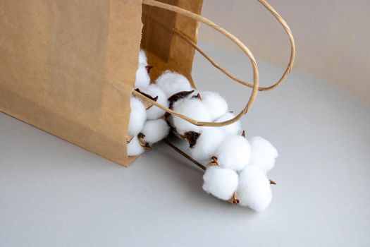 Organic eco-friendly paper bag with cotton flowers on a gray background. Zero waste and eco-friendly concept.