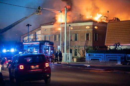 VILLANOVA DEL GHEBBO, ITALY 23 MARCH 2021: House burning at night with firefighters