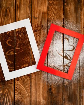 photo frames with heart and coffee silhouette from coffee and powdered sugar on wooden background