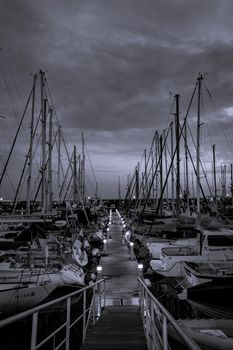 Row of yatchs and sailing boats moored in a marina at dusk