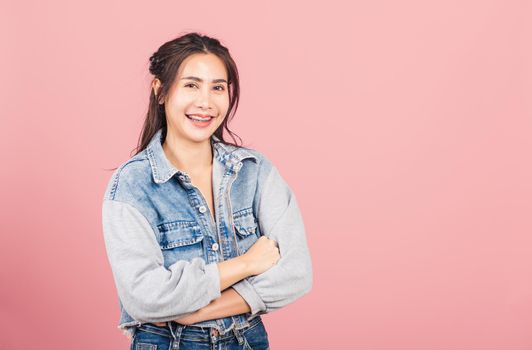 Asian happy portrait beautiful cute young woman wear denim standing her smile confidence with crossed arms isolated, studio shot on pink background and copy space, Thai female looking to camera