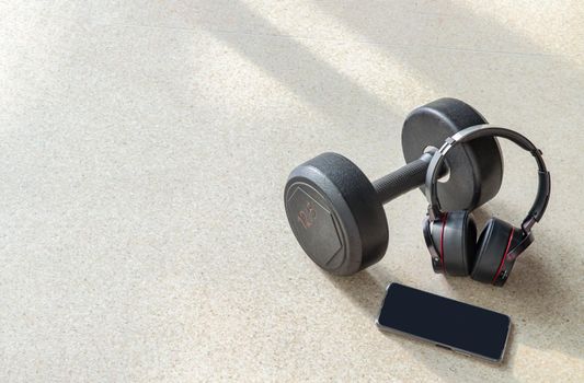 Composition of Smartphone, Headphones and Dumbbell for Listening to music while exercising. Copy space, Selective focus.