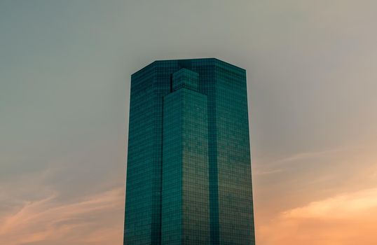 Bangkok, Thailand - Dec 28, 2020 : Angular geometric mirror cladding on a modern building with repeating structure and reflected sky background at evening time. No focus, specifically.