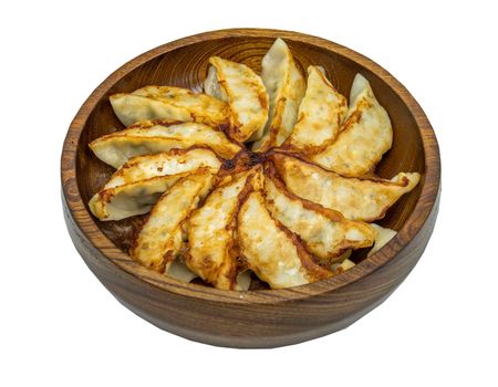 Asian dinner : Fried japanese gyoza dumplings on wooden bowl isolated on white background with clipping path. Selective focus.