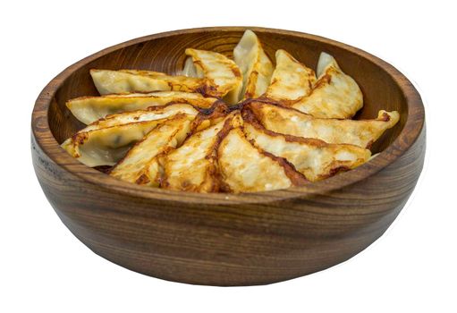 Asian dinner : Fried japanese gyoza dumplings on wooden bowl isolated on white background with clipping path. Selective focus.