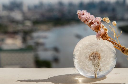 Dried flowers on Crystal glass in river background. World Environment concept. Copy space.