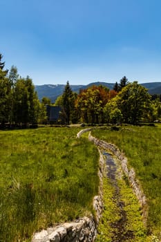 Small river down the mountain in Jizera mountains at sunny day