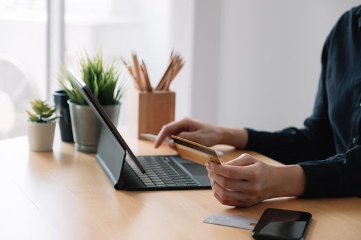 Close up hand of woman making online payment using laptop for shopping at home