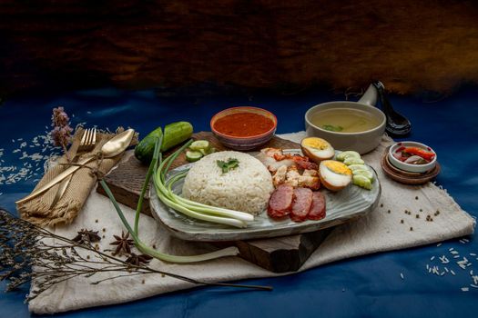 Red pork with rice (Kao Moo Dang) : Thai Style Red Barbecue Pork, duck egg and crispy pork belly, sliced cucumber with red sauce and broth.