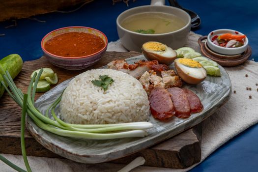 Red pork with rice (Kao Moo Dang) : Thai Style Red Barbecue Pork, duck egg and crispy pork belly, sliced cucumber with red sauce and broth.