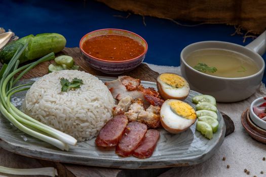 Red pork with rice (Kao Moo Dang) : Thai Style Red Barbecue Pork, duck egg and crispy pork belly, sliced cucumber with red sauce and broth.