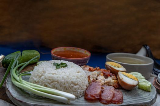 Red pork with rice (Kao Moo Dang) : Thai Style Red Barbecue Pork, duck egg and crispy pork belly, sliced cucumber with red sauce and broth.