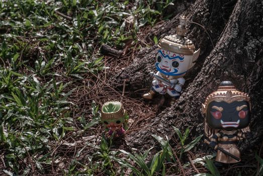 Ravana, Giantess and Hanuman. Standing on the base of a large tree at the park. Traveller doll.
