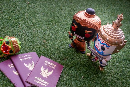 Bangkok, thailand - Nov 22, 2018 : Ravana and giantess  Standing staring at Hanuman sleep side next to passport. Traveller doll. Selective focus.