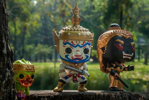 Ravana, Giantess and Hanuman. Standing on the base of a large tree at the park. Traveller doll.
