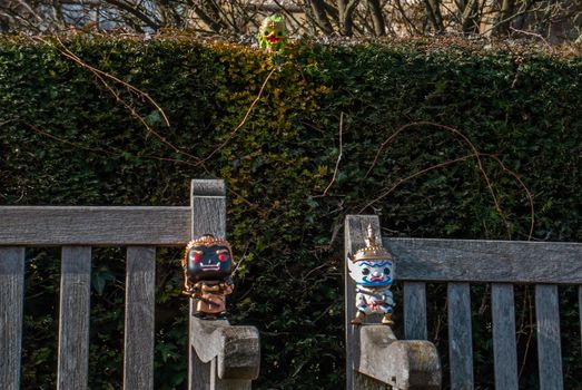 Ravana and Giantess and Hanuman Sitting on the backrest of the wooden chair at the park. Traveller doll.