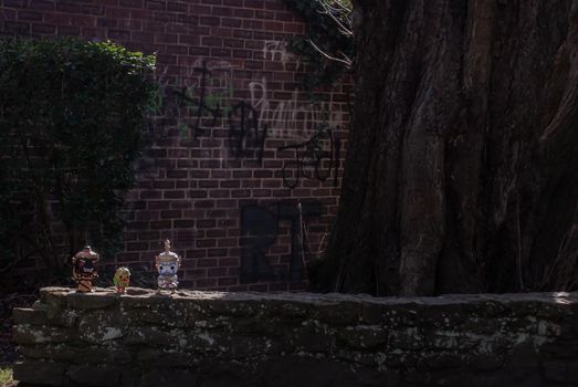 Ravana, Giantess and Hanuman Standing on a stone fence around a large tree In the cemetery. Traveller doll.