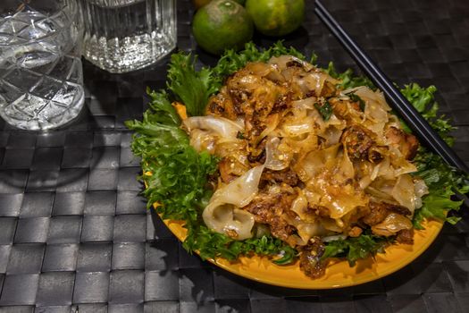Stir fried flat rice noodle and pork with dark soy sauce. Thai Food. No focus, specifically.