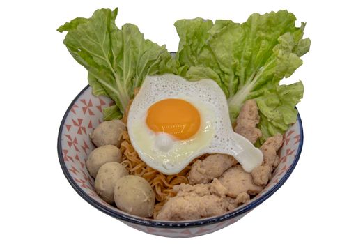 Boil egg noodles with pork ball, minced pork, fried egg and vegetables isolated on white background with clipping path. Selective focus.