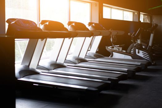 Empty treadmill standing gym near big window Nobody Fitness sport healthy lifestyle concept