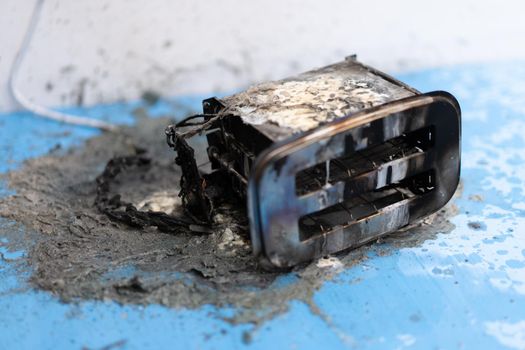 Toaster after fire. Household electrical appliance fire hazard. Overload. Short circuit. Carelessness. Safety in home. Danger home inflammation Insurance concept