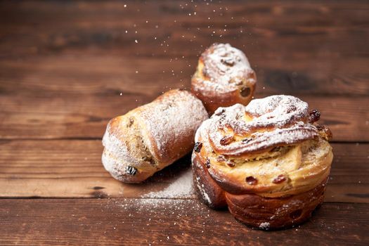 Traditional easter cake Kraffin stands on wooden table against a dark background. Spring holiday bread with copy space