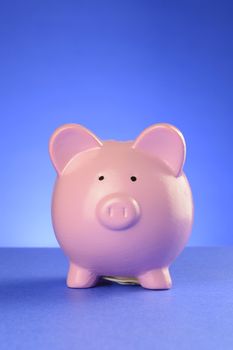 A pink piggy bank facing frontwards over a blue gradient background.