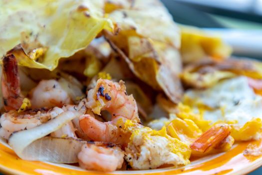 Breakfast with Omelet, Baked Shrimp, Onion and Deep fried Dumplings. Close-up, Selective focus.
