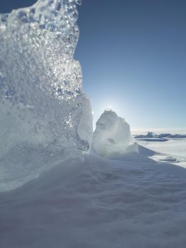 Ice slopes in sunny winter day, transparent ice of blue color, purely blue sky, long shadows, a pure snow-covered virgin soil, snow barkhans, . High quality photo