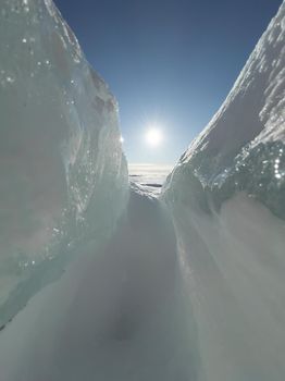 Ice slopes in sunny winter day, transparent ice of blue color, purely blue sky, long shadows, a pure snow-covered virgin soil, snow barkhans, . High quality photo