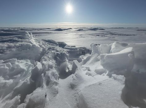 Ice slopes in sunny winter day, transparent ice of blue color, purely blue sky, long shadows, a pure snow-covered virgin soil, snow barkhans, . High quality photo