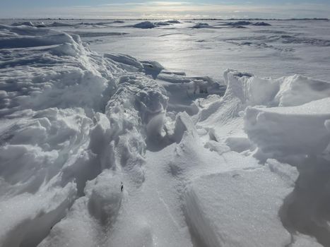 Ice slopes in sunny winter day, transparent ice of blue color, purely blue sky, long shadows, a pure snow-covered virgin soil, snow barkhans, . High quality photo