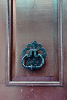 Black knocker on a dark wooden door