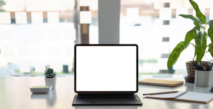 Digital tablet with white blank screen on table. workspace concept