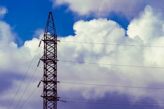 A high-voltage tower against a cloudy sky.