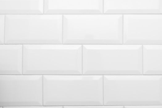 Part of a white glossy brick wall. Large glossy brick decorative tiles. 