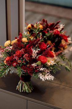 red elegant wedding bouquet of fresh natural flowers and greenery