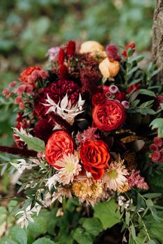 red elegant wedding bouquet of fresh natural flowers and greenery