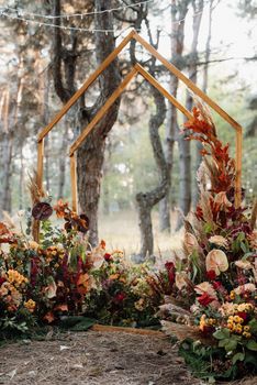 wedding ceremony area with dried flowers in a meadow in a pine brown forest