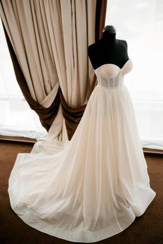 ivory wedding dress with a train on a black mannequin