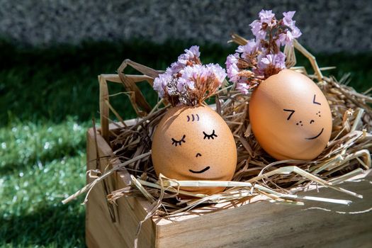 The two happy eggs is lying on dry straw. Happy and relaxing concept.