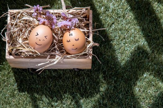 The two happy eggs is lying on dry straw. Happy and relaxing concept.
