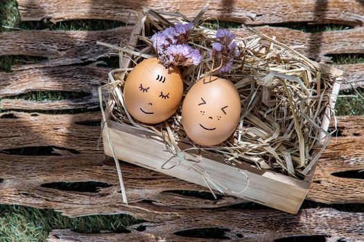 The two happy eggs is lying on dry straw. Happy and relaxing concept.